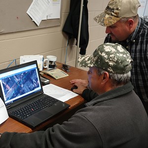Two men working on laptop in office